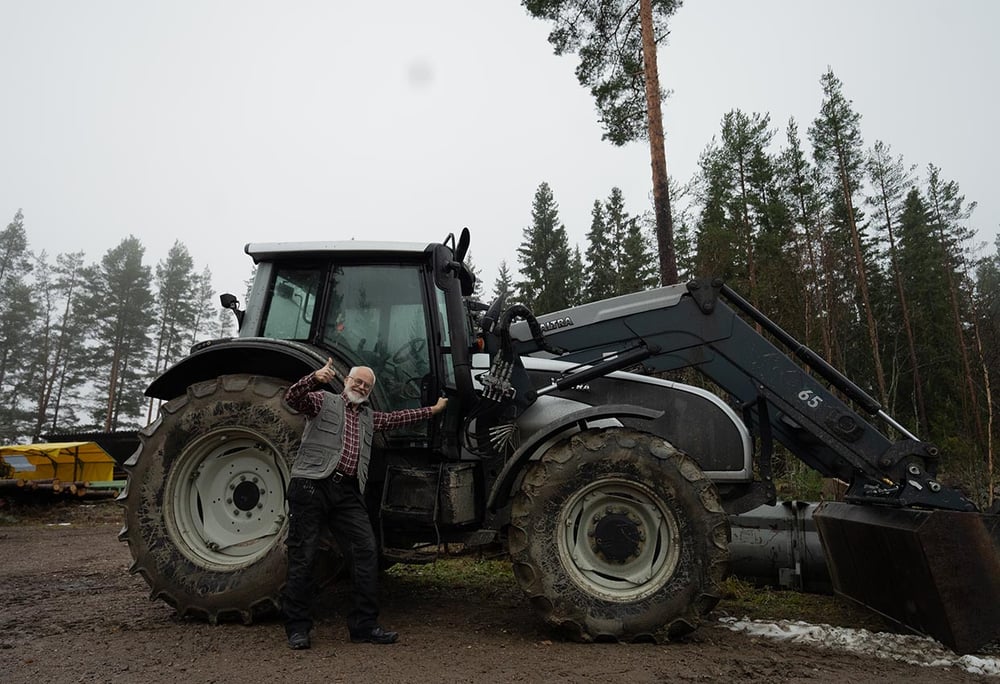 onnellinen mies traktorin kanssa